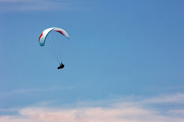 Parapentiste dans le ciel du Grand Bornand dans les Alpes. Le parapente est un aéronef dérivé du parachute, permettant la pratique du vol libre ou du paramoteur 