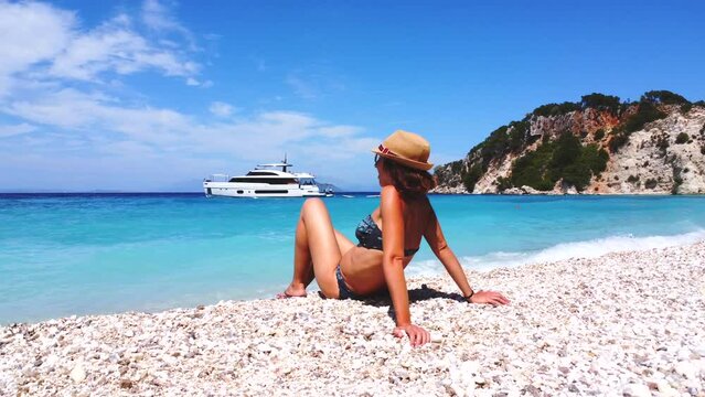 Portrait of a tourist woman resting on the Gidaki Beach on the island of Ithaki or Ithaca in the Ionian sea in the Mediterranean sea of Greece