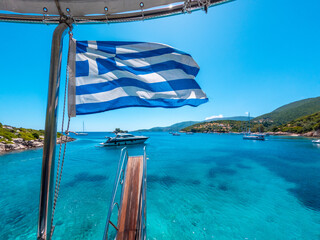 Greek flag on boat cruise around the island of Ithaki or Ithaca in the Ionian sea in the...
