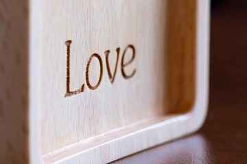 Carved text love on wooden frame