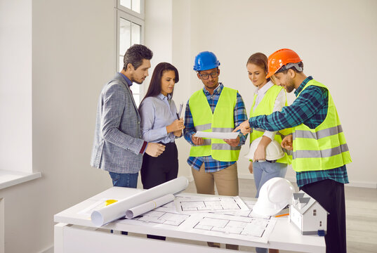 Homeowner couple discussing home renovation plan with professional builders. Renovation crew looking at blueprints and explaining about plan with homeowners for renovation, remodeling of apartment