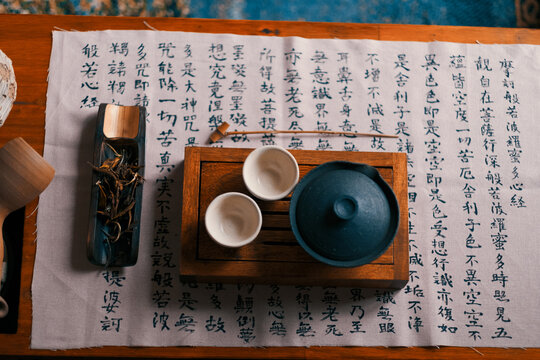 Escritura japonesa y cuencos de t&eacute; en una mesa