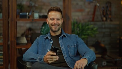 Portrait of happy man with phone at home
