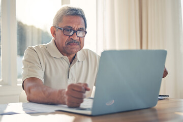 Senior man, laptop and documents in finance or budget planning or checking bills and expenses at home. Mature male person working on computer, paperwork or insurance in retirement plan or investment