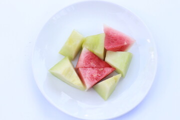 fresh slices of watermelon and melon served on a white plate
