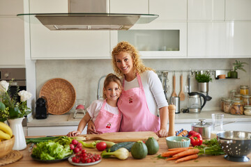 Mother and daughter preparing tasty food at home
