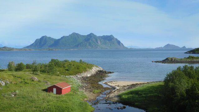 Drone rising above a beautiful surreal looking river near city of Svolvaer and Vatterfjordtinden mountain in the arctic archipelago in Lofoten, Norway