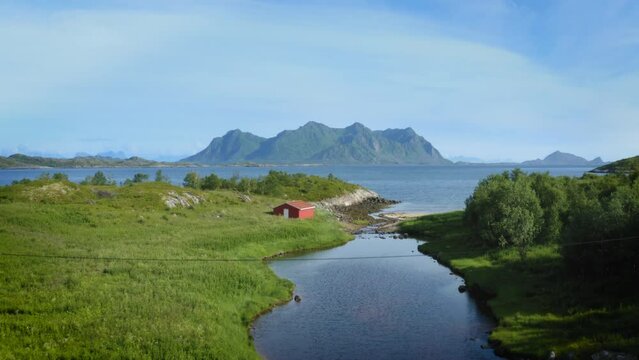 Description: Drone rising above a beautiful surreal looking river near city of Svolvaer and Vatterfjordtinden mountain in the arctic archipelago in Lofoten, Norway