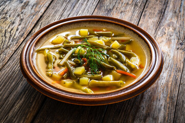 Green bean soup on wooden table
