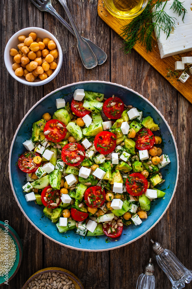 Wall mural fresh vegetable salad with feta cheese on wooden table - Wall murals