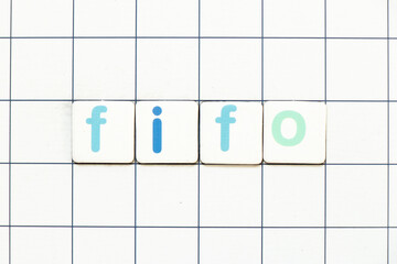 Colorful tile letter in word FIFO (Abbreviation of first in first out) on white grid background