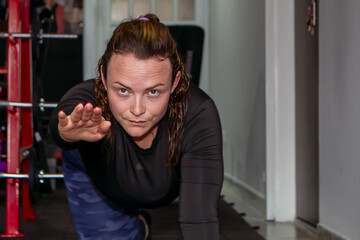 sporty woman doing stretching before exercising in a gym