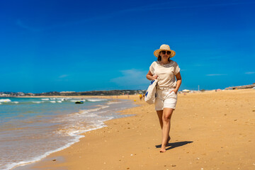 Beautiful woman walking on sunny beach
