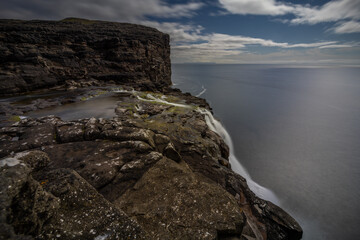 Bosdalafossur waterfall at slave cliff and floating lake, Traelanipa, Sorvagsvatn, Vagar, Faroe...