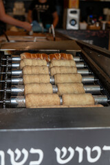Traditional Trdelnik Pastries Baking on a Rotating Grill in Prague