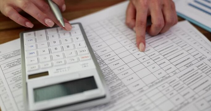 Businesswoman use calculator and check finances, income and budget of company. Business woman calculates monthly expenses