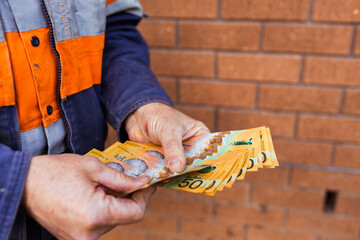 Handyman holding bank notes counting cash received as payment for job completion