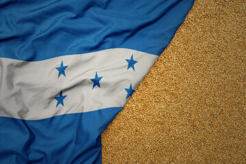 wheat grain on the waving colorful big national flag of honduras .