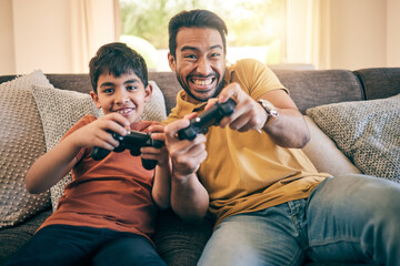 Family, fun and a boy gaming with his father on a sofa in the living room of their home together for competition. Video game, children and a man learning how to play from his gamer son in the house © Charlize Davids/peopleimages.com