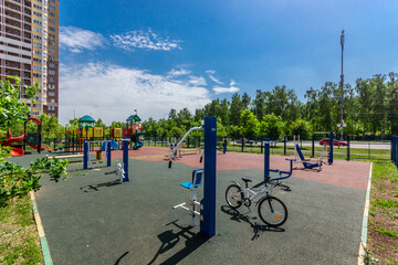 A sports ground with special equipment on the landscaped territory of a modern residential complex on a sunny summer day.