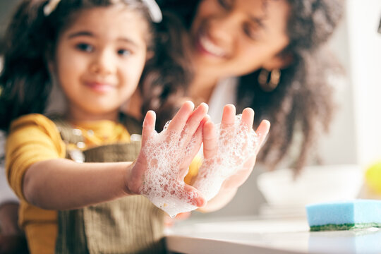 Soap, cleaning hands and family with child in bathroom for learning healthy hygiene routine at home. Closeup, mom and girl kid washing palm with foam for safety of bacteria, dirt or germs on skincare