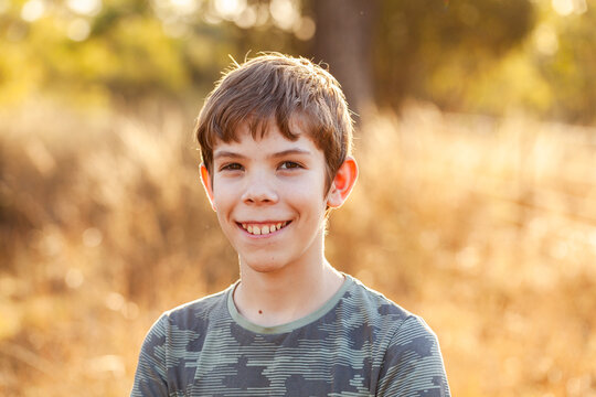 Portrait of a pre-teen boy in rural Australia outside in golden light with paddock backdrop