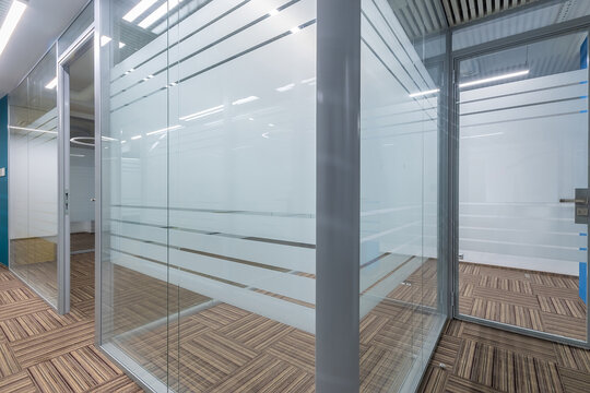 Fototapeta Cubicle office with glass partitions and doors. Floor covering with a beautiful geometric .pattern.