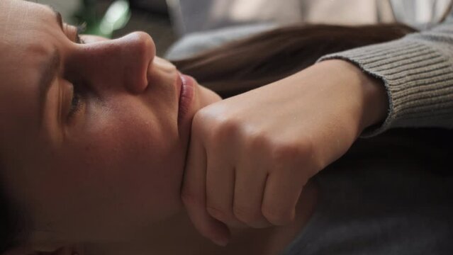 Vertical footage of depressed frustrated young Caucasian woman suffering from headache, migraine, touching face, feeling stressed, sick, tired, thinking over bad news, problems, crisis concept
