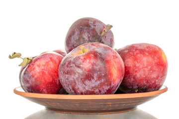 Several ripe juicy red apples on a clay plate, macro, isolated on white background.
