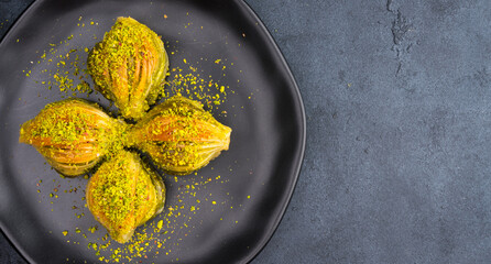 Mussel shaped baklava with pistachio on black  background
