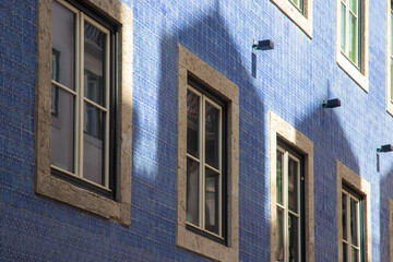 A house with windows and the shadow of a different building 