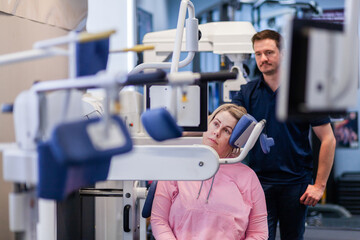 female physio client with physiotherapist using medical strengthening equipment