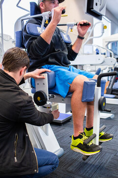 Physio adjusting exercise therapy equipment for client
