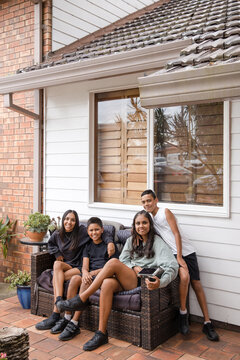 First nations family sitting together on couch outside