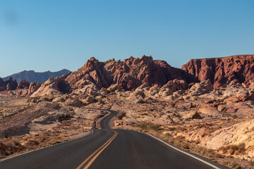 Panoramic view of endless winding empty road in Valley of Fire State Park leading to red Aztec...