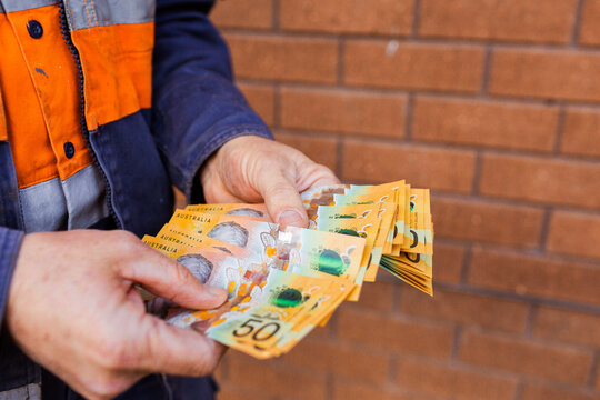 Handyman holding bank notes counting cash received as payment for job completion