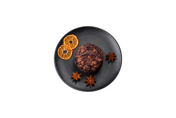 Delicious fresh oatmeal round cookies with chocolate on a black ceramic plate