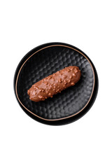 Delicious fresh eclair cake or profiterole with chocolate and nuts