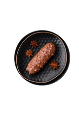 Delicious fresh eclair cake or profiterole with chocolate and nuts