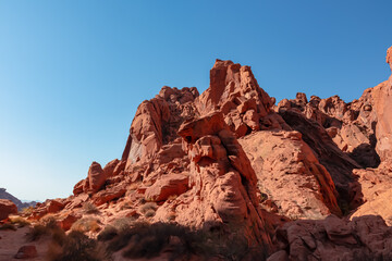 Fototapeta na wymiar Panoramic view of red Aztek sandstone rock formations in Petroglyph Canyon along Mouse Tank hiking trail in Valley of Fire State Park in Mojave desert, Nevada, USA. Hot temperature in arid vegetation