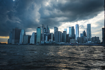 Lower Manhatten photographed from the east River. This foto includes a dramatic sky with the...