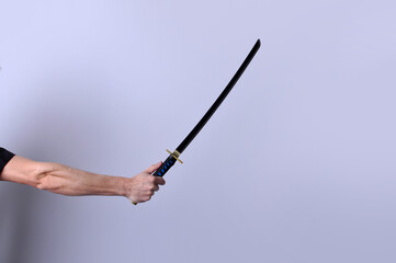 mão segurando espada chinesa 
