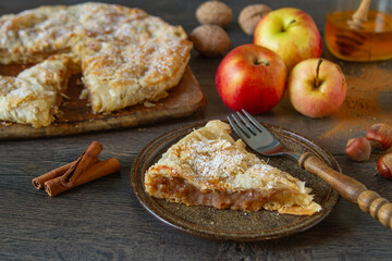 Traditional rustic apple pie with fruit, nuts and autumn spices on a table