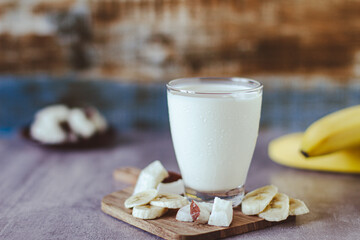 Fresh sweet healthy coconut milkshake with bananas on a table