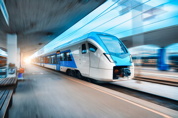 Blue high speed train in motion on the railway station. Fast moving modern intercity train and blurred background. Railway platform. Railroad in Slovenia. Commercial. Passenger railway transportation