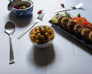 Indian street food chhole or chickpea masala served with tikia. Close up, selective focus.