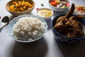 Indian meal steamed rice and chicken curry served with condiments. Close up, selective focus.