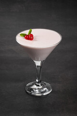 Vegan dessert. Red currant cream jelly, Panna Cotta, decorated with fresh red currant berries, in a martini glass. Dark background