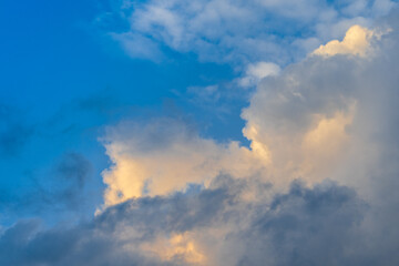 Naklejka na ściany i meble A beautiful Cloudscape of orange and white cumulus clouds in a clear blue sky