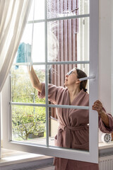 Woman washes window, house cleaning